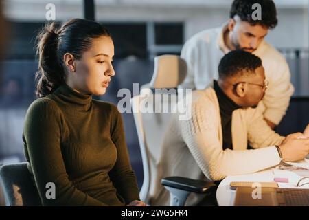 Diverse business team collaborating late in the evening to achieve business growth and profitability. Stock Photo