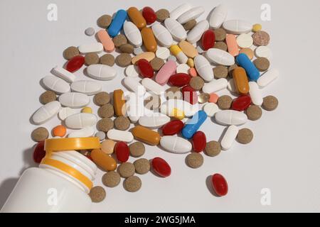 Close-up, Pills scattered on the table. Many pills of different colors and shapes. Antipyretics, painkillers and antibiotics. Background with copy spa Stock Photo