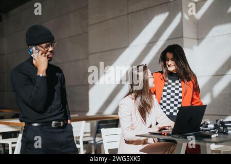 Young teammates engaged in a casual business meeting at a bright cafe. Stock Photo