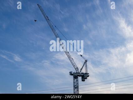 Towering crane - soft blue sky with wispy clouds - cables and pulleys - construction. Taken in Toronto, Canada. Stock Photo