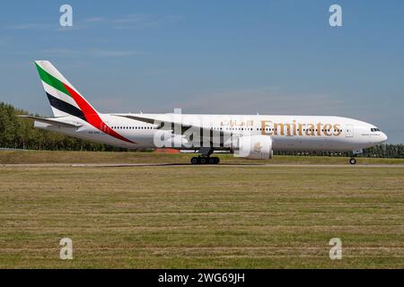 Emirates Boeing 777-200 with registration A6-EWC rolling on taxiway V of Amsterdam Airport Schiphol Stock Photo