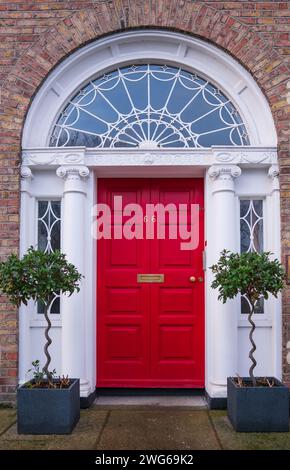 Colorful red georgian door in Dublin, Ireland. Historic doors in different colors painted can be seen in dublin. Stock Photo