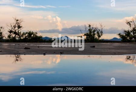 In the twilight, water on a concrete floor with clouds and the sky. Water on a concrete surface surrounded by clouds and sky. Stock Photo