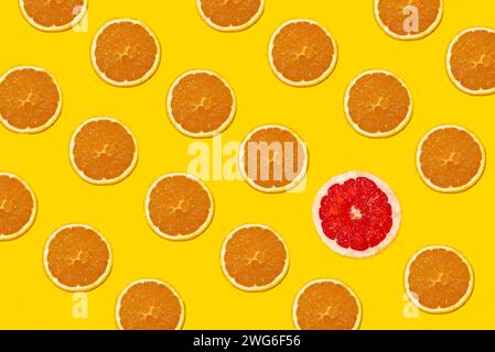 Pattern of orange slices with a red grapefruit slice breaking through the sample. Stock Photo