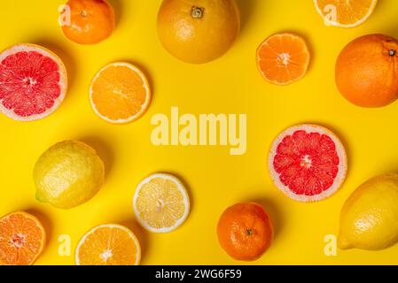 Collage of citrus fruits, whole, half and sliced, grapefruits, oranges, lemons and tangerines, on a yellow background. Stock Photo