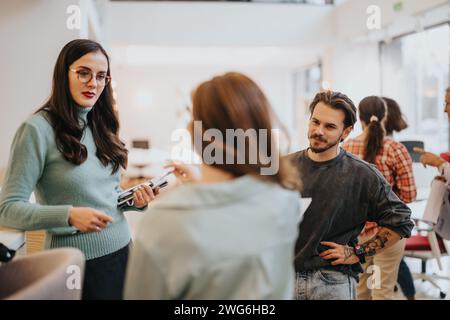 Contemporary office scene with young professionals engaged in discussion. Stock Photo