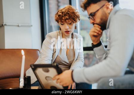 Young adults discussing market analysis in a corporate office Stock Photo