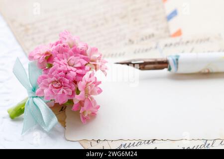 Beautiful tiny bouquet of pink kalanchoe blossfeldiana flowers and vintage letters, copy space Stock Photo