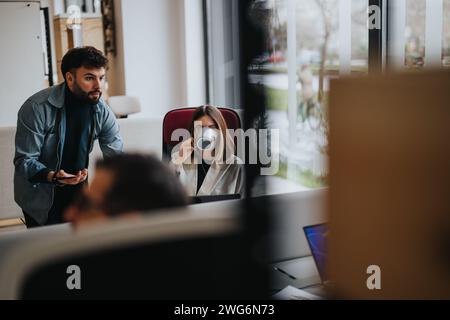 Colleagues engaged in discussion at modern office workspace. Stock Photo