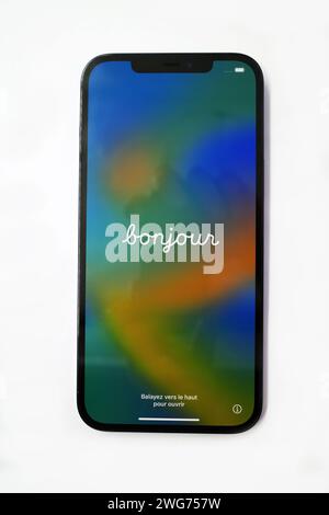 Itterbeck, Germany -Feb 2 2023 Front, screen side, of an Apple iPhone 12 Pro Max. The word Bonjour is displayed on the screen. This is French and and Stock Photo