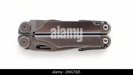 Folded steel multitool isolated on white background, top view. A tool for daily practice. All in one. Construction and repair. Compact and portable pr Stock Photo