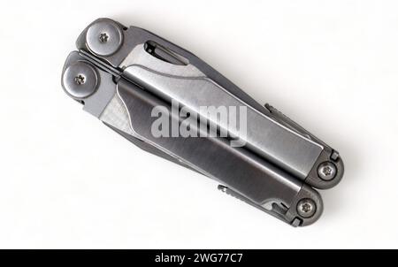 Folded steel multitool isolated on white background, top view. A tool for daily practice. All in one. Construction and repair. Compact and portable pr Stock Photo