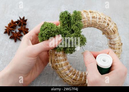 Florist at work: how to make christmas door wreath with moss and dry hortensia flowers. Step by step, tutorial. Stock Photo