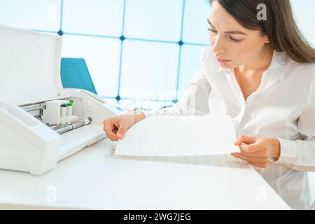 female designer makes a layout of an advertising brochure on a plotter Stock Photo