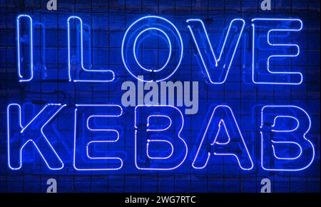 Neon shining sign in blue color on a brick wall with the inscription or slogan I love kebab. Brick wall, background. Bright electric neon light. Cafe- Stock Photo