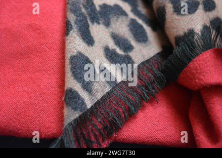 Very beautiful leopard coloring, leopard print black and beige color background in blots, dots on red fabric. Stock Photo