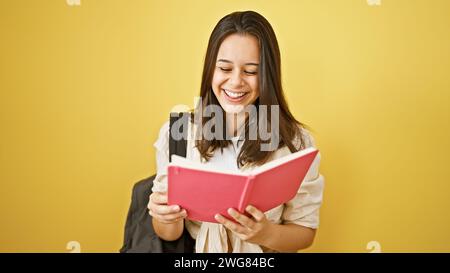 Joyful young hispanic woman with beautiful hairstyle standing confident, cheery, looking cool. casually dressed college student with backpack reading Stock Photo