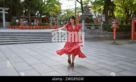 Cheerful beautiful hispanic woman captivatingly spinning around in traditional dress, illuminating the old yasaka temple street, kyoto, with radiance. Stock Photo