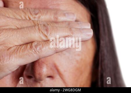 Close up of a mature woman with her hand covering her eyes Stock Photo