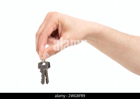Cropped shot of a side view of home keys hanging from a man hand isolated on a white background Stock Photo