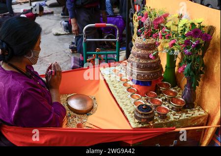 A Tibetan woman worships at a small alter outside the Jokhang Temple in Lhasa. Stock Photo