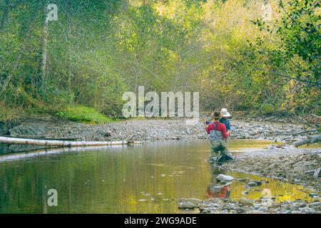 Man showing children how to fly fish in the afternoon. Stock Photo