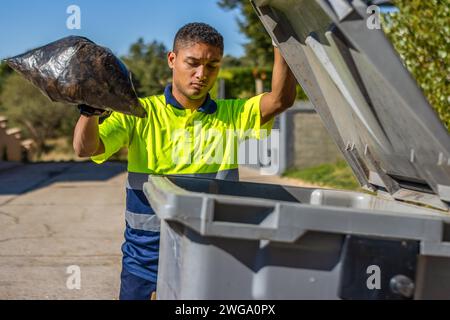Man putting garbage bag in the trash can. Person putting garbage bags in place Stock Photo