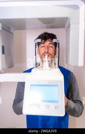 Young man in the x-ray room having an x-ray done on a client in the modern dental clinic Stock Photo