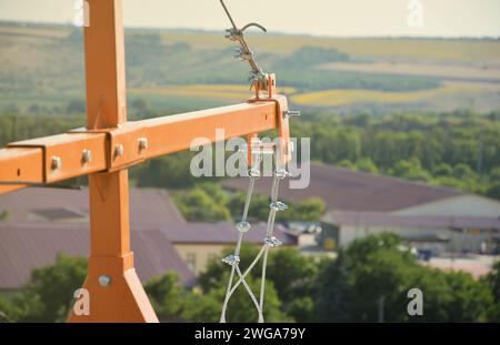 Rope lockers in ending of front beam of suspended wire rope platform for facade works on high multistorey buildings. Rope lockers blocks rope kink for safety platform usage Stock Photo