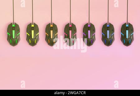 Several computer mice hang on a pastel pink background. The concept of cooperative computer video games, the use of auto-clicker and pay-per-click platforms. Flat lay abstract minimal composition Stock Photo
