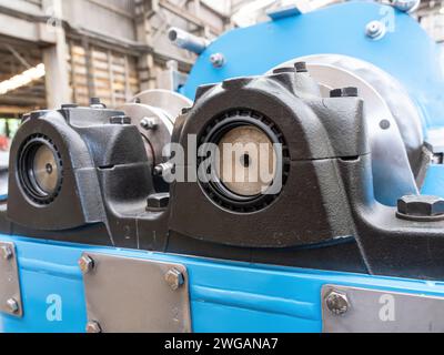 Bearing housings and drive shafts on an industrial twin screw press. Shallow depth of field with the nearest bearing in focus. Stock Photo