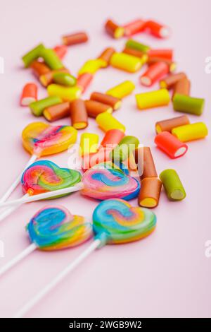 Colorful sweet jelly candies and lollipops on the pink background. Stock Photo