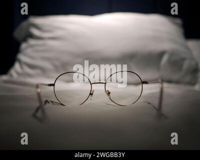 An eyeglasses optics on white linen bed, low light night time, shortsighted, nearsighted, farsighted, eyewear business products, relax or rest or slee Stock Photo