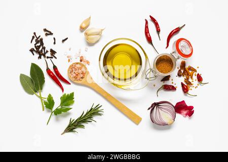 variety of herbs and spices, a bowl with olive oil are arranged on white background. view from above Stock Photo
