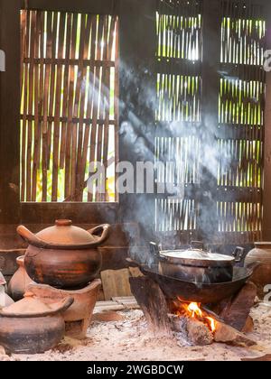 Kitchen at a traditional wooden Thai house with cooking over open flames. Stock Photo