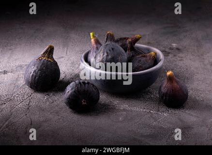 Some ripe figs in a bowl on a textured gray background Stock Photo