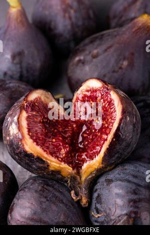background with fresh and ripe figs, in the foreground an open fig forms a heart. Stock Photo
