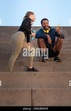 Young athletes using apps on the phone to keep track of their exercise routine.Vertical Stock Photo