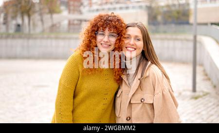 Two women standing smiling together in the street Stock Photo