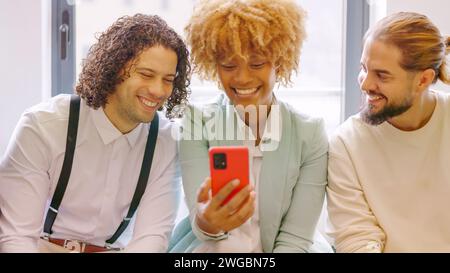 Coworkers using phone sitting relaxed during a break Stock Photo