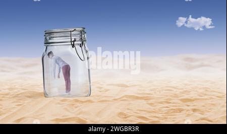 Desperate young woman trapped in a glass jar in the desert Stock Photo