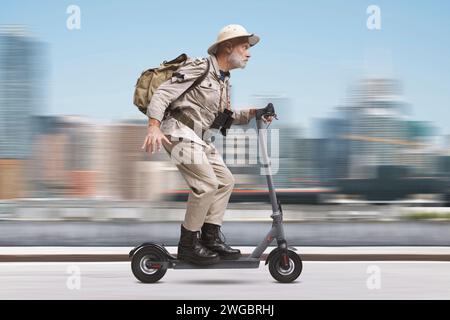 Funny senior urban explorer riding a fast electric scooter in the city street Stock Photo