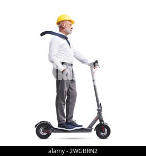 Professional senior architect wearing a safety helmet and riding an electric scooter, isolated on white background Stock Photo