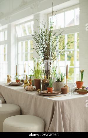 Festive Easter table setting with painted Easter eggs, spring flowers and candles Stock Photo