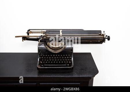 Antique typewriter on a desk isolated on white background. Stock Photo