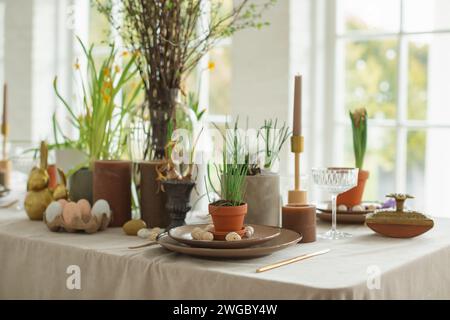 Festive Easter table setting with painted Easter eggs, spring flowers and candles Stock Photo