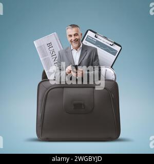 Businessman using a smartphone and office items in a briefcase, business solutions concept Stock Photo