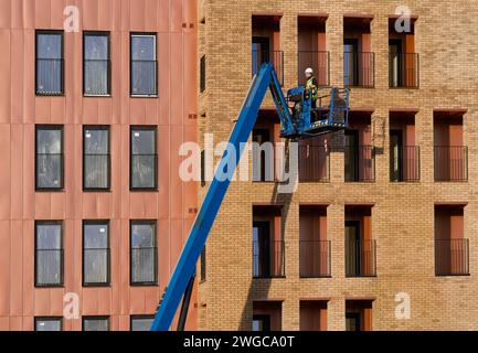 Scissor lift being operated by construction workmen for safe access at height Stock Photo