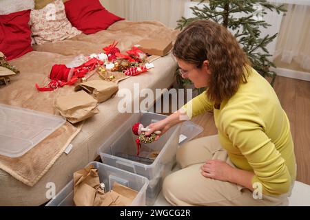 Cleaning up Christmas tree decorations in the home room after Christmas is over. Preparing for the New Year's celebration and unpacking the decor Stock Photo