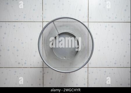 Empty of Silver mesh wastebasket on the tile floor Stock Photo